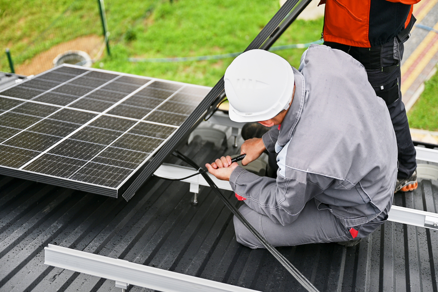 Ein Man montiert eine Solaranlage