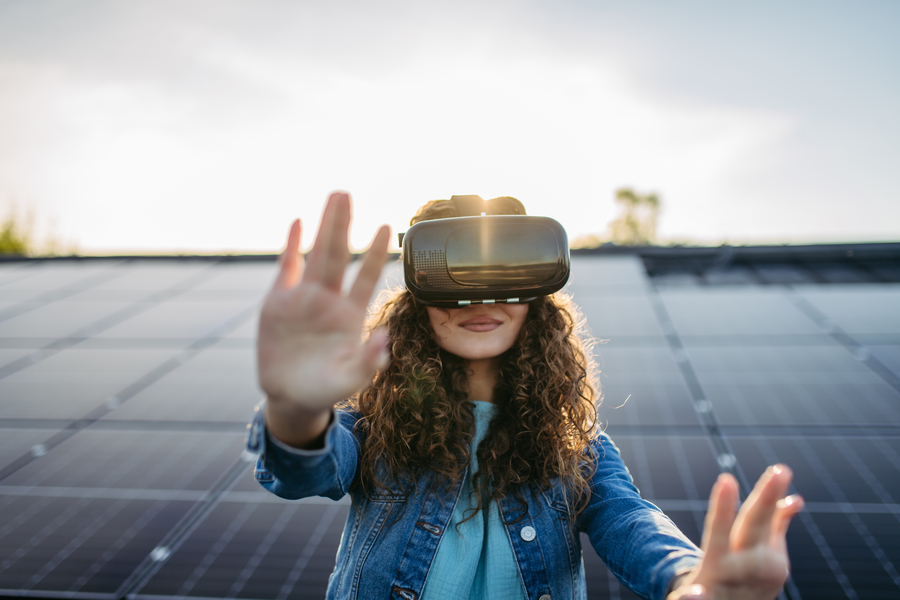 Eine Frau mit VR Brille vor einer Solaranlage